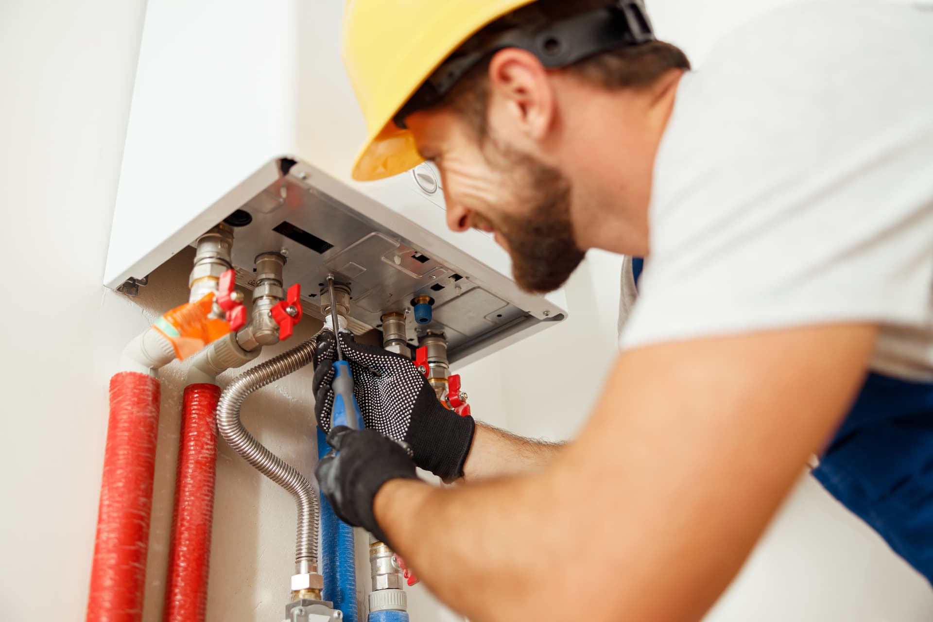Electrician bending down to work on furnace unit